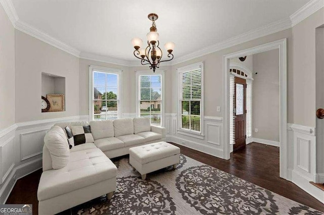 living room featuring dark wood-type flooring, ornamental molding, and an inviting chandelier