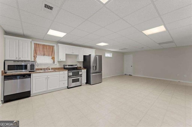 kitchen featuring white cabinetry, appliances with stainless steel finishes, sink, and a drop ceiling