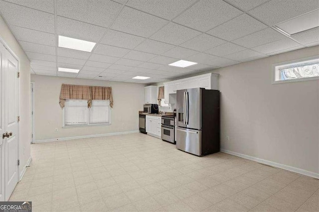 kitchen featuring a paneled ceiling, appliances with stainless steel finishes, and white cabinets