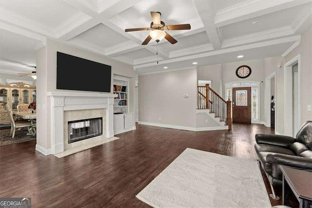 living room featuring a fireplace, beamed ceiling, dark hardwood / wood-style flooring, ornamental molding, and coffered ceiling