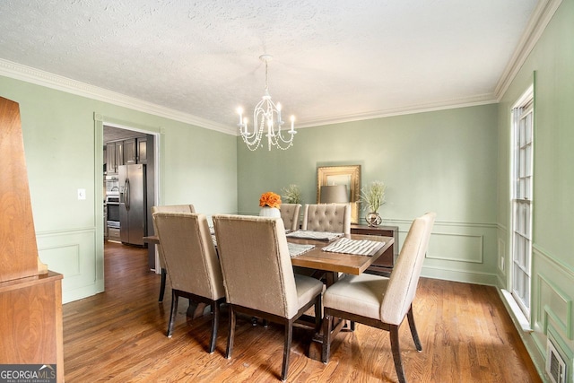 dining space featuring a notable chandelier, dark hardwood / wood-style floors, and a textured ceiling