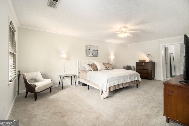 carpeted bedroom featuring ceiling fan, ornamental molding, and a textured ceiling