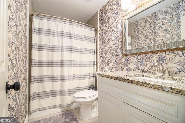 bathroom featuring tile patterned floors, toilet, a textured ceiling, and vanity