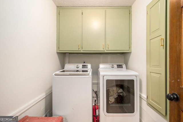 laundry room with cabinets, separate washer and dryer, and a textured ceiling