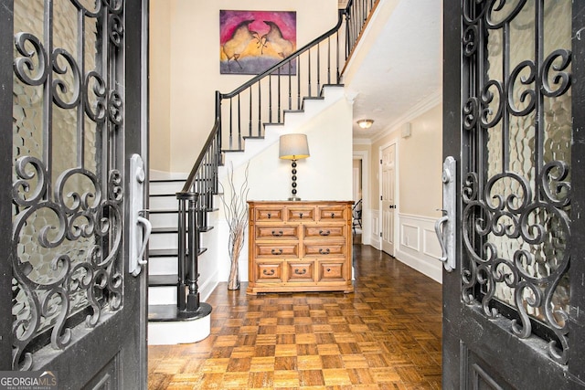 entrance foyer with dark parquet flooring and ornamental molding