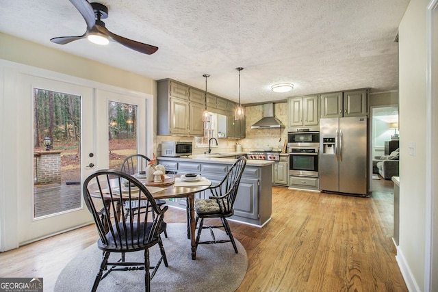 dining space featuring sink, light hardwood / wood-style flooring, french doors, and a textured ceiling