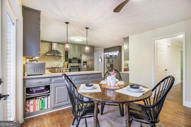 dining space with dark wood-type flooring, ceiling fan, and a textured ceiling