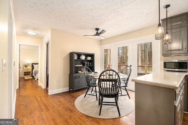 dining area featuring dark hardwood / wood-style floors, a textured ceiling, and ceiling fan