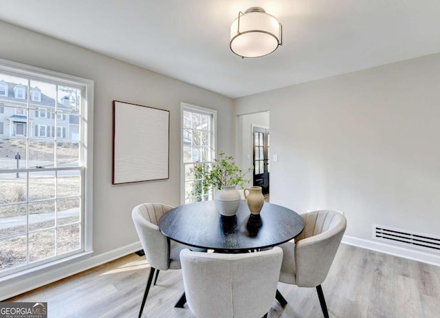 dining space with plenty of natural light and light hardwood / wood-style flooring