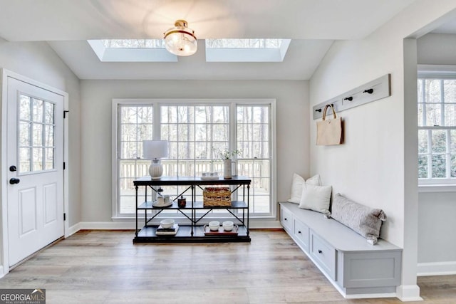 mudroom with light hardwood / wood-style floors and vaulted ceiling with skylight