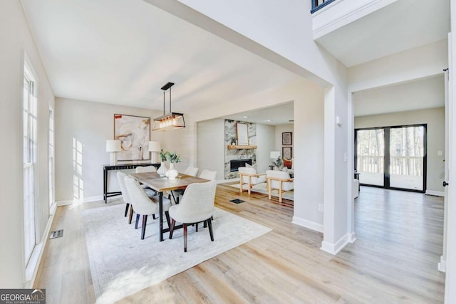 dining room with a fireplace and light hardwood / wood-style flooring