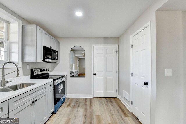 kitchen featuring stainless steel appliances, sink, and light hardwood / wood-style flooring