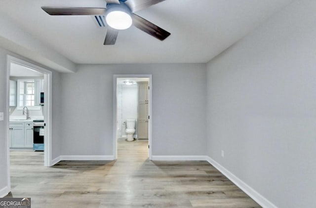 spare room with sink, ceiling fan, and light wood-type flooring