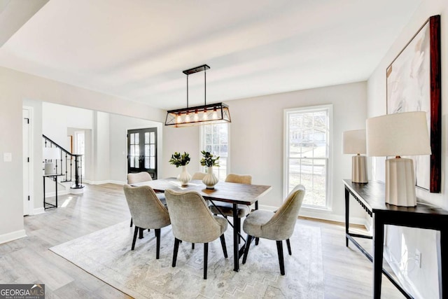 dining area with french doors and light hardwood / wood-style floors