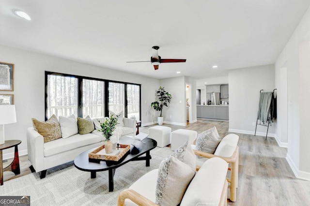 living room featuring ceiling fan and light wood-type flooring