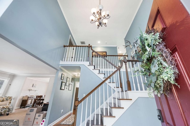 stairs featuring a notable chandelier, crown molding, carpet, and a towering ceiling