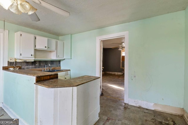 kitchen featuring white cabinetry, ceiling fan, sink, and a textured ceiling