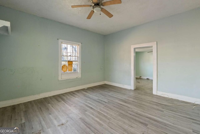 spare room featuring ceiling fan, light hardwood / wood-style flooring, and a textured ceiling