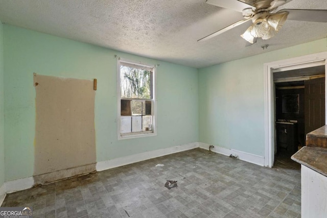 empty room featuring ceiling fan and a textured ceiling