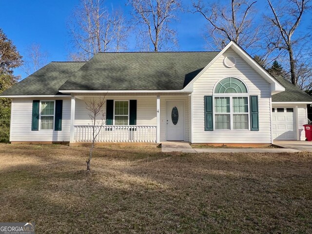 single story home featuring a garage, a front lawn, and a porch