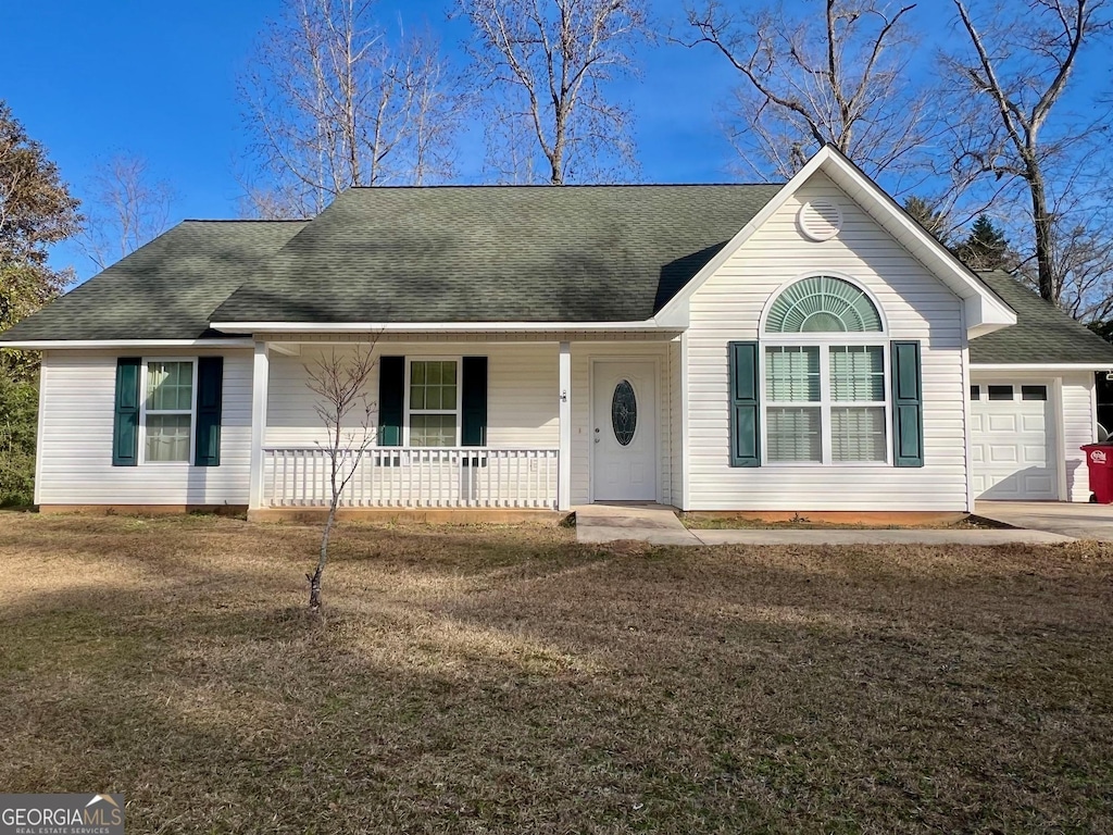 ranch-style home featuring a garage, a front yard, and covered porch