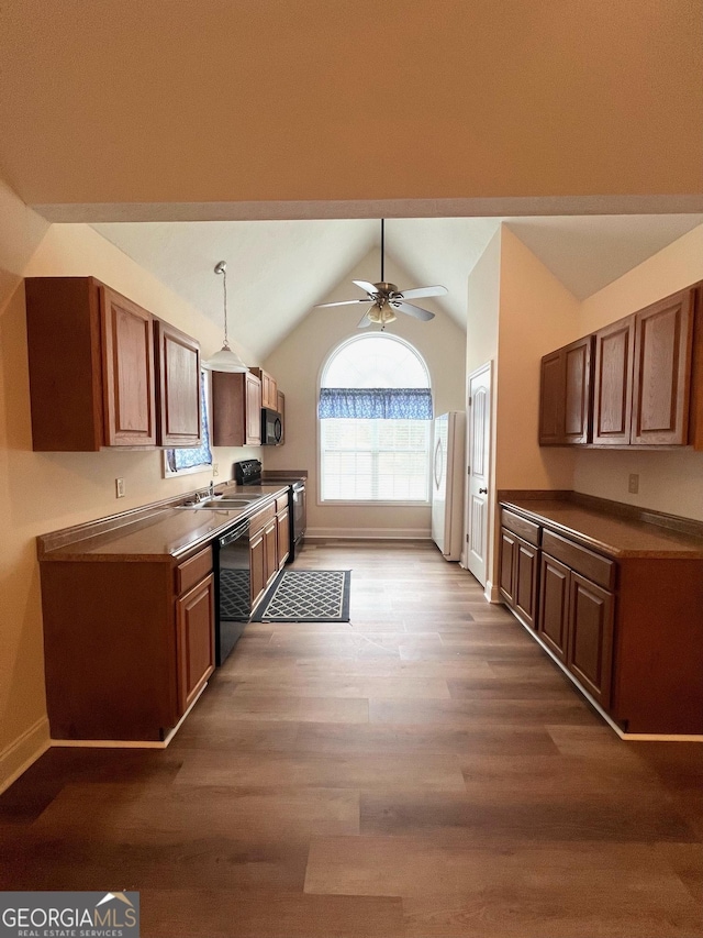 kitchen with lofted ceiling, hardwood / wood-style flooring, ceiling fan, hanging light fixtures, and black appliances