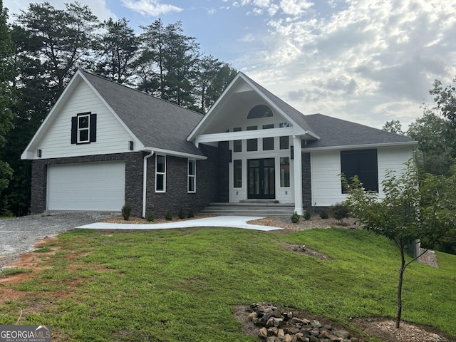 view of front of property with a garage, a front yard, and french doors