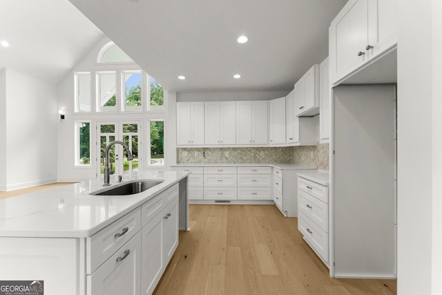 kitchen featuring tasteful backsplash, sink, and white cabinets