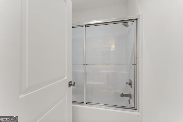 bathroom featuring combined bath / shower with glass door