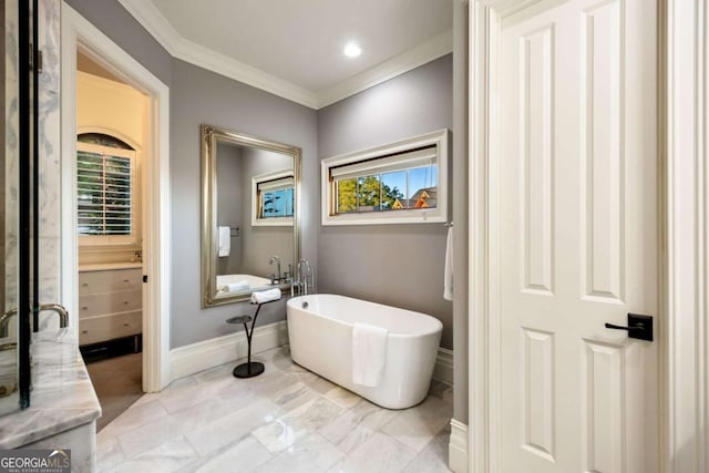 bathroom featuring a soaking tub, baseboards, a wealth of natural light, and crown molding