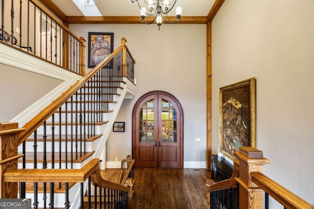 entryway with baseboards, arched walkways, dark wood-style floors, french doors, and a chandelier