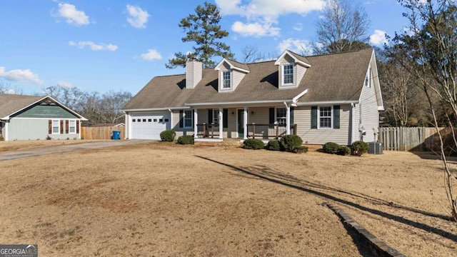 cape cod-style house featuring a garage and covered porch