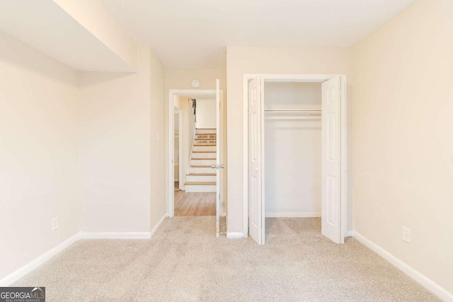 unfurnished bedroom featuring a closet and light carpet