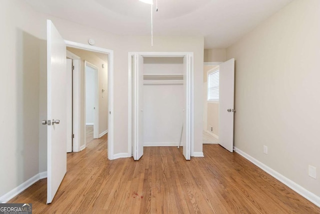 unfurnished bedroom featuring a closet and light wood-type flooring