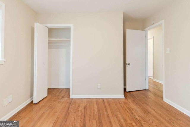 unfurnished bedroom featuring light hardwood / wood-style floors and a closet