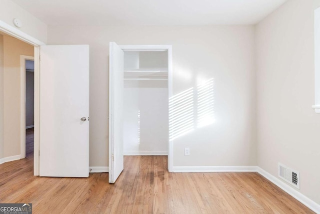 unfurnished bedroom with a closet and light wood-type flooring