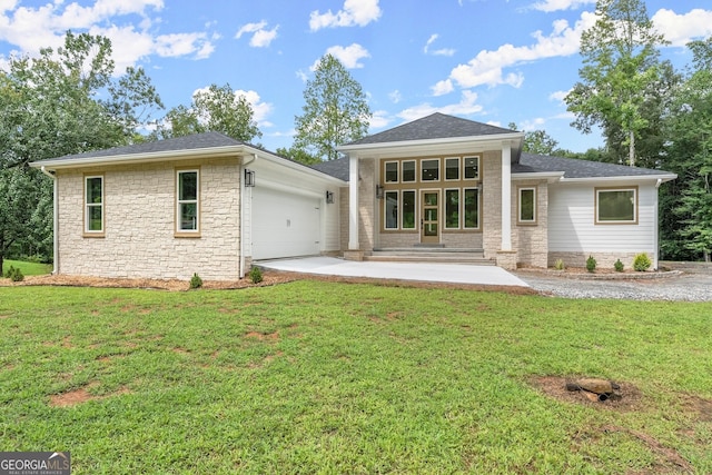 back of property with a garage and a yard