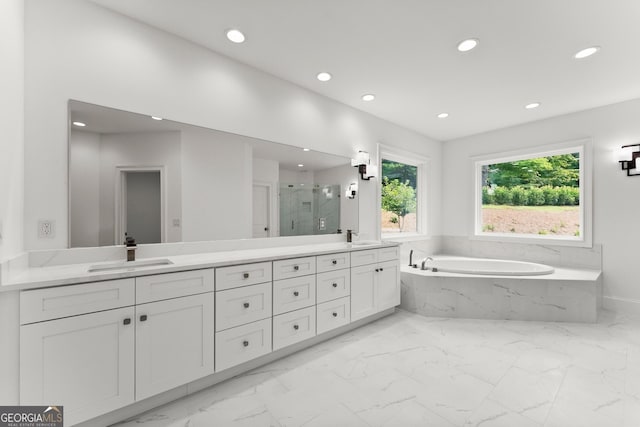 bathroom featuring vanity and independent shower and bath