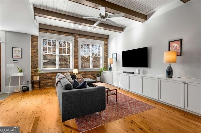 living room featuring wooden ceiling, light wood-type flooring, beamed ceiling, ceiling fan, and brick wall