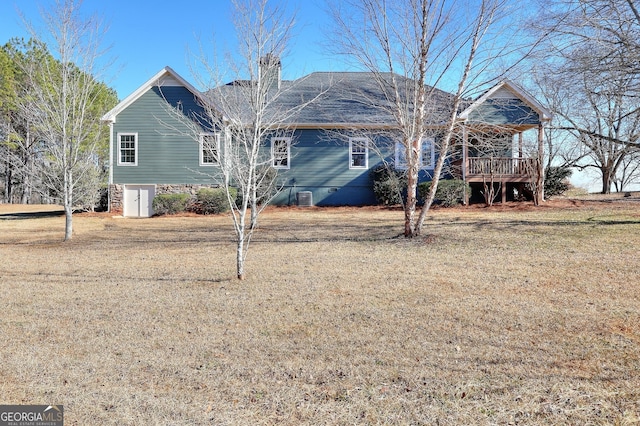 view of front of property featuring a wooden deck, a front lawn, and central air condition unit