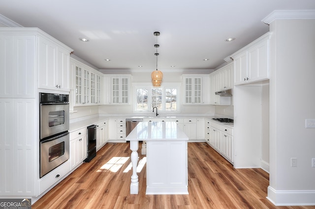 kitchen with white cabinetry, stainless steel appliances, a kitchen bar, and a center island