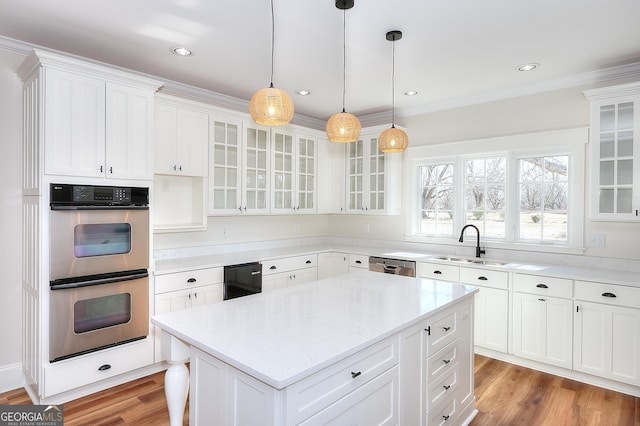 kitchen featuring pendant lighting, white cabinetry, a center island, light stone counters, and stainless steel appliances