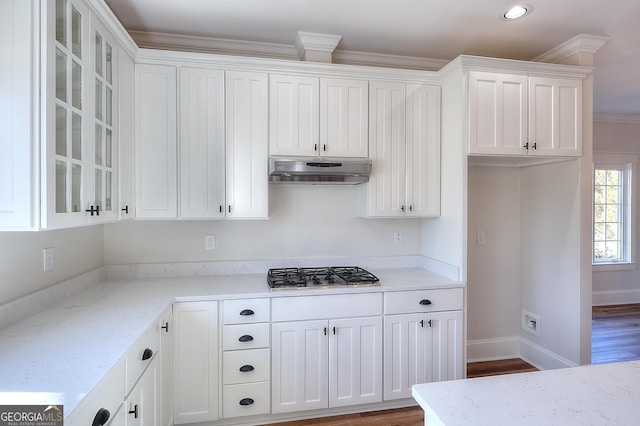 kitchen with stainless steel gas cooktop, light stone counters, wood-type flooring, ornamental molding, and white cabinets