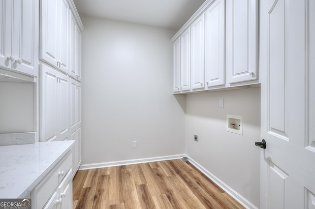 clothes washing area featuring cabinets, hookup for a washing machine, light hardwood / wood-style flooring, and electric dryer hookup