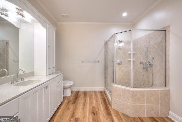 bathroom featuring toilet, hardwood / wood-style floors, crown molding, and walk in shower