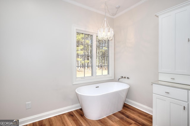 bathroom with ornamental molding, a bath, wood-type flooring, and a notable chandelier