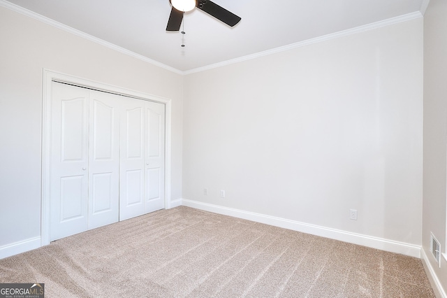 unfurnished bedroom featuring crown molding, carpet floors, and a closet