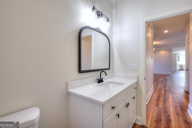 bathroom featuring vanity, hardwood / wood-style floors, and toilet