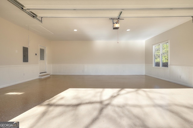 garage with a garage door opener and electric panel