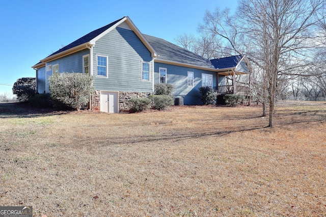 view of side of home with cooling unit and a lawn